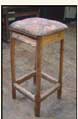 Stool legs made of a quartered fir sapling, stool legs arranged in the same orientation as when sapling was split (see drawing). Seat is piece of foam rubber, covered by piece of old Oriental carpet. Steel strap holds legs together at bottom.