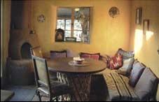 Kitchen sitting area, corner seat of adobe, walls painted with homemade casein paints